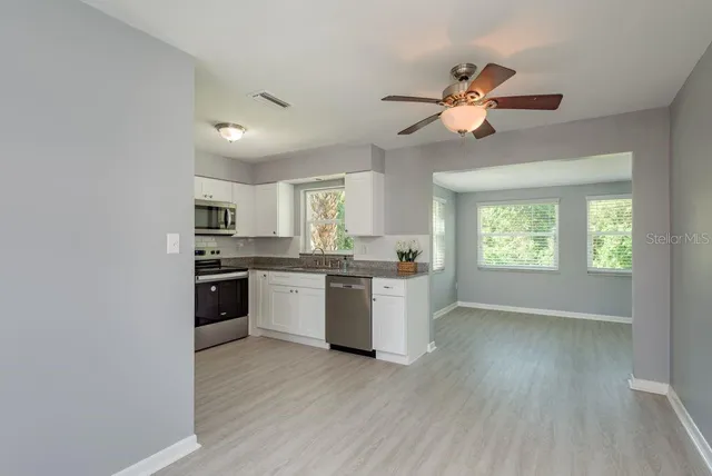a kitchen with stove and wooden floor