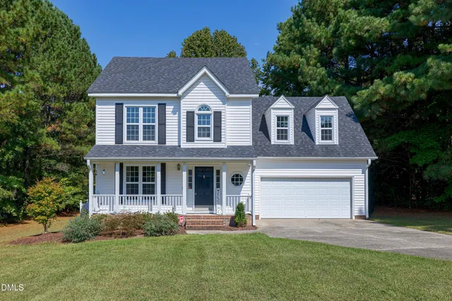 a front view of a house with a garden and yard