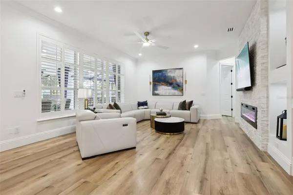 a large white kitchen with a refrigerator a sink dishwasher a oven and white cabinets with wooden floor