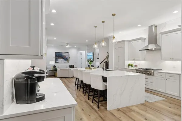 a kitchen with stainless steel appliances granite countertop a stove a sink and white cabinets