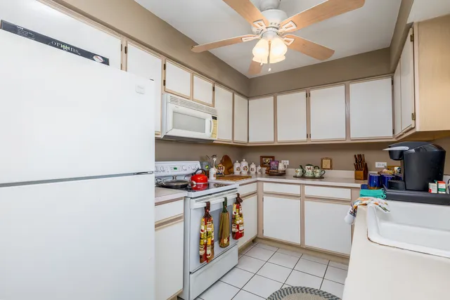a kitchen with a sink a refrigerator and cabinets