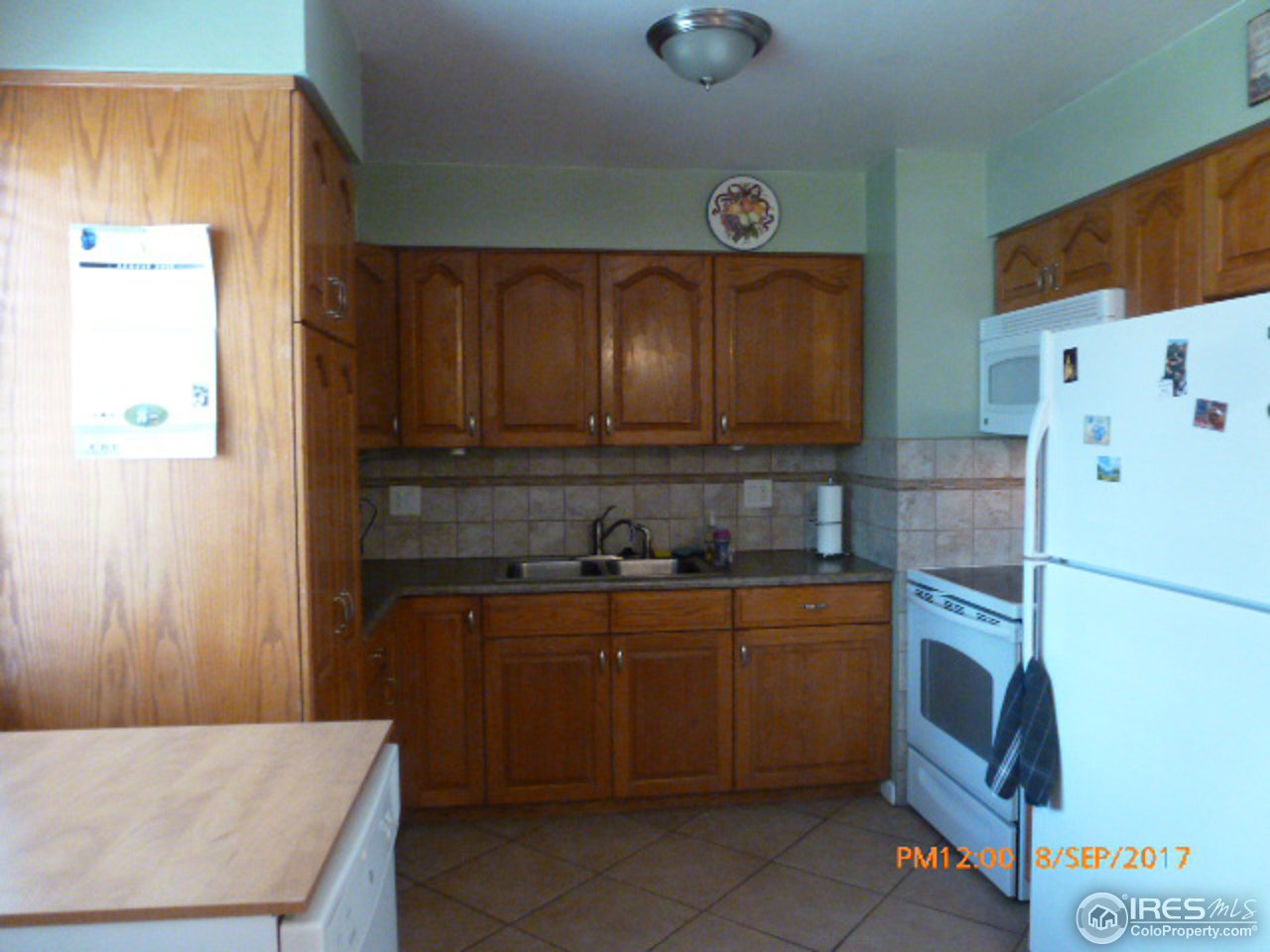 3317 West 5th St Road Greeley, CO 80634 - Photo 10 of 20 a kitchen with a refrigerator and a stove top oven