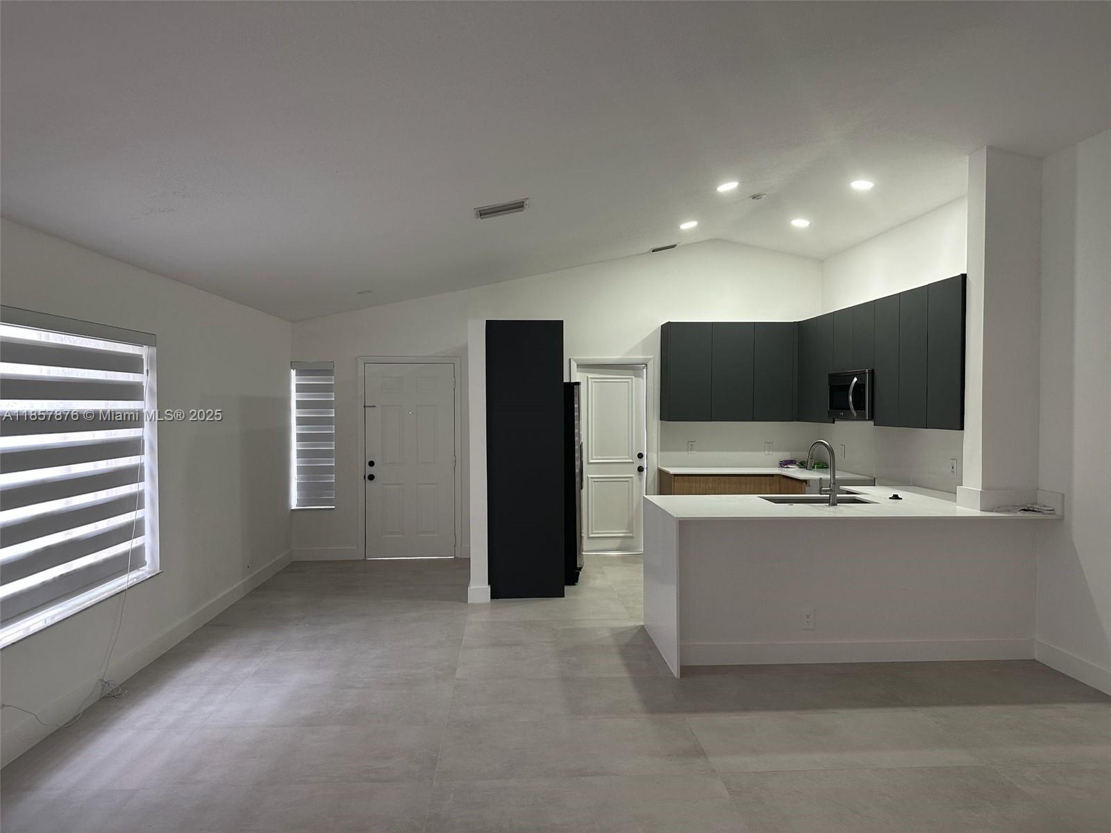 591 Talavera Road Weston, FL 33326 - Photo 9 of 35 a view of cabinets with stainless steel appliances wooden floor and window