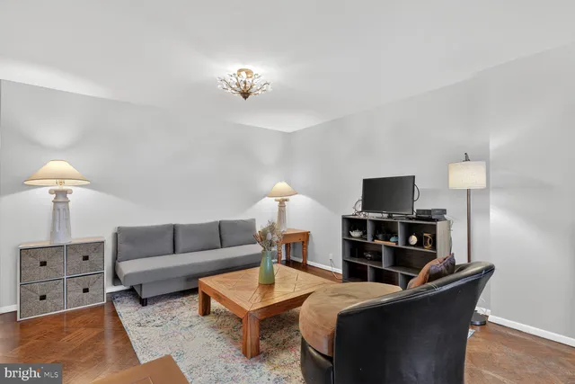 a living room with furniture a lamp and a flat screen tv