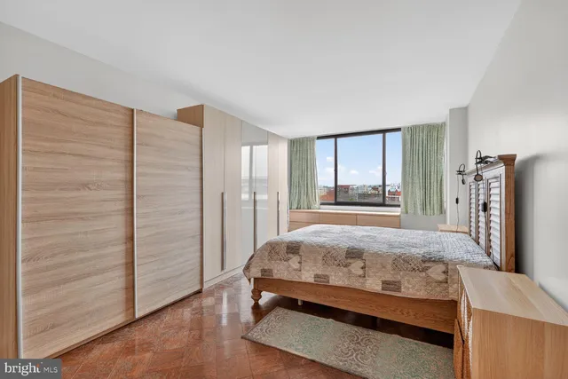 a bed sitting in a spacious bedroom next to a window