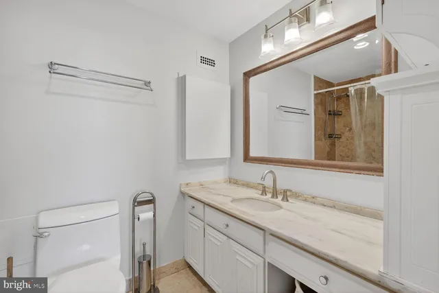 a bathroom with a granite countertop sink a mirror and a shower