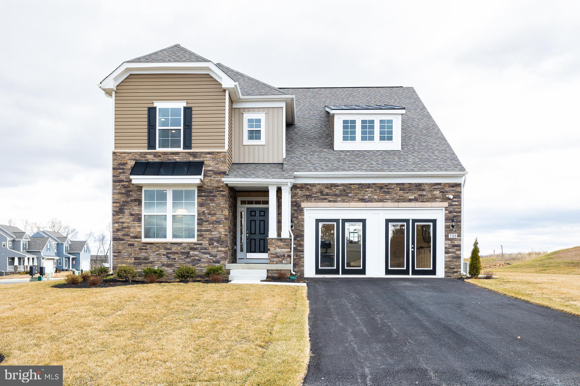 a front view of a house with yard and ocean view