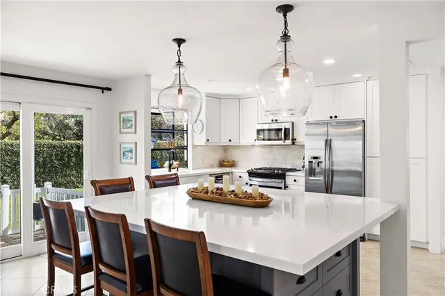 a kitchen with a dining table chairs and refrigerator