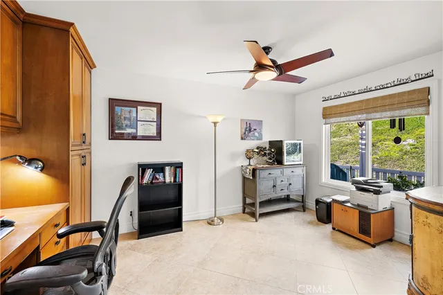 a view of a workspace with furniture and a window
