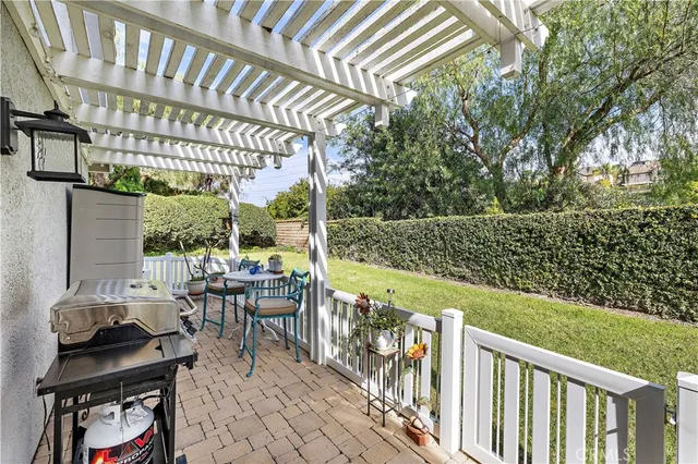 a view of a chair and tables in the patio next to a yard