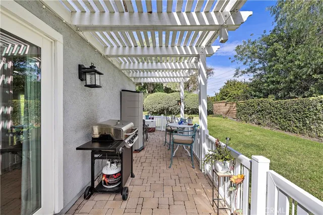 a view of a patio with table and chairs with wooden floor and fence
