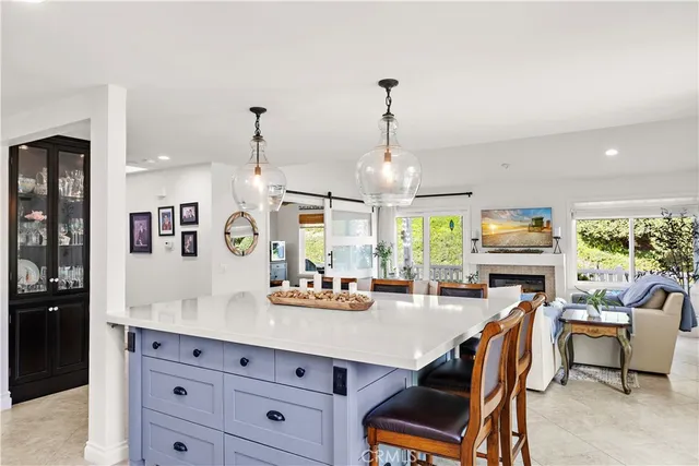 a room with stainless steel appliances kitchen island granite countertop furniture and a view of living room