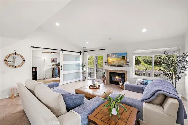 a living room with furniture fireplace and a large window