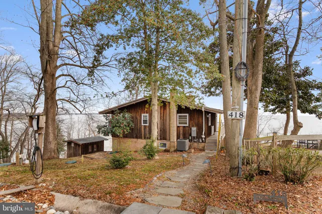 a view of an empty room with wooden floor and a fireplace