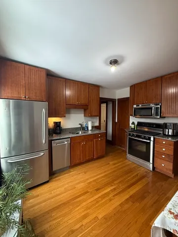 a kitchen with stainless steel appliances wooden cabinets a refrigerator and a stove top oven