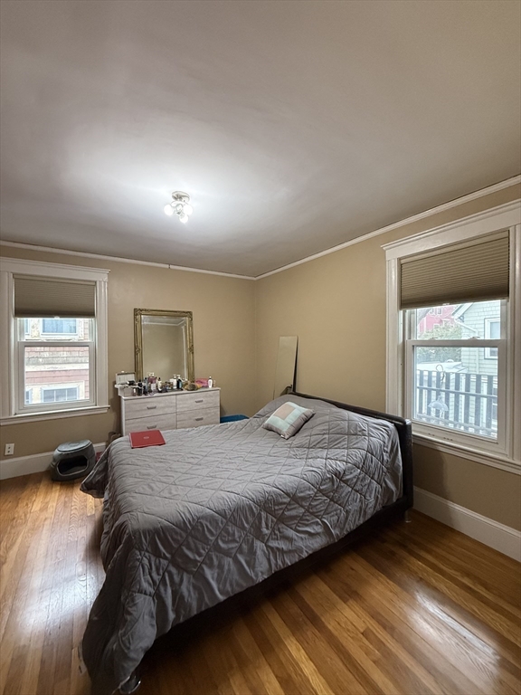 7 View S Avenue, Unit 3 Boston, MA 02130 - Photo 10 of 14 a bedroom with a bed and a dresser with wooden floor