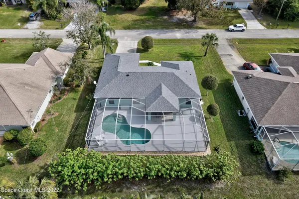 an aerial view of a house with a garden and lake view