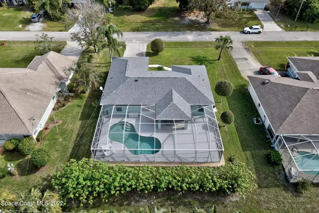 an aerial view of a house with a garden and lake view