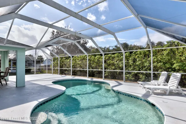 a backyard of a house with fountain table and chairs