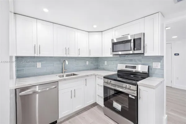 a kitchen with cabinets stainless steel appliances and a sink