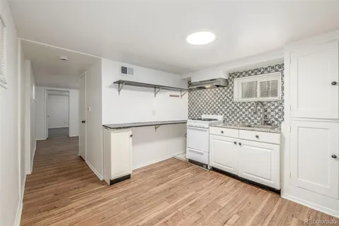 a kitchen with white cabinets and white appliances
