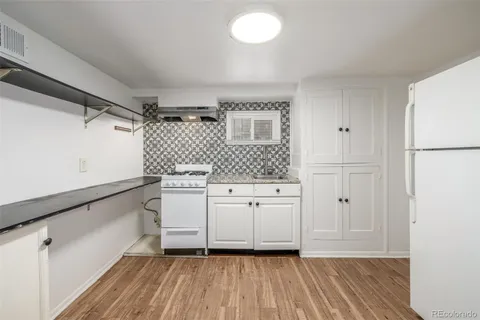 a view of a kitchen with white cabinets and a sink