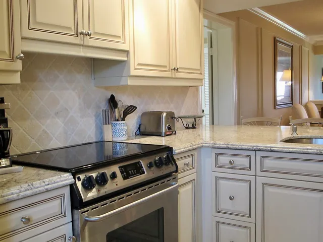 a kitchen with granite countertop white cabinets and white appliances