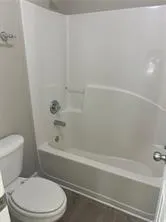 a white toilet and tub sitting next to a bathroom sink