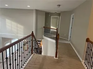 a view of a hallway with a door and stairs