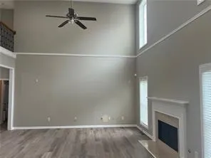 a view of empty room with wooden floor and fireplace