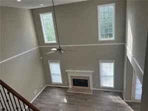 an empty room with windows and fireplace