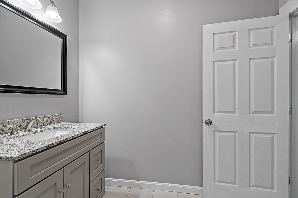 46 West Meadow Road Lowell, MA 01854 - Photo 24 of 42 a bathroom with a granite countertop sink and vanity