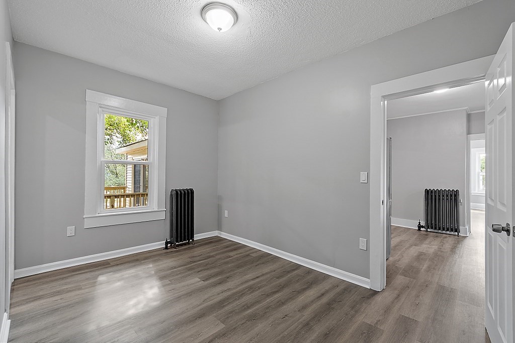 46 West Meadow Road Lowell, MA 01854 - Photo 27 of 42 an empty room with wooden floor a ceiling fan and windows
