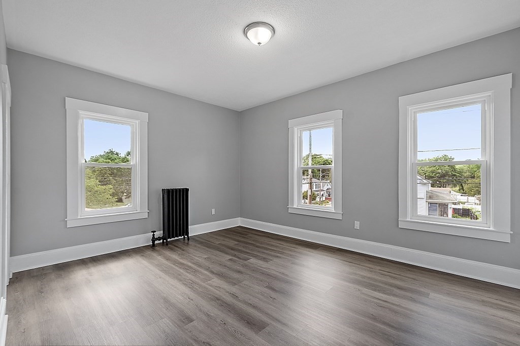 46 West Meadow Road Lowell, MA 01854 - Photo 32 of 42 an empty room with wooden floor and windows
