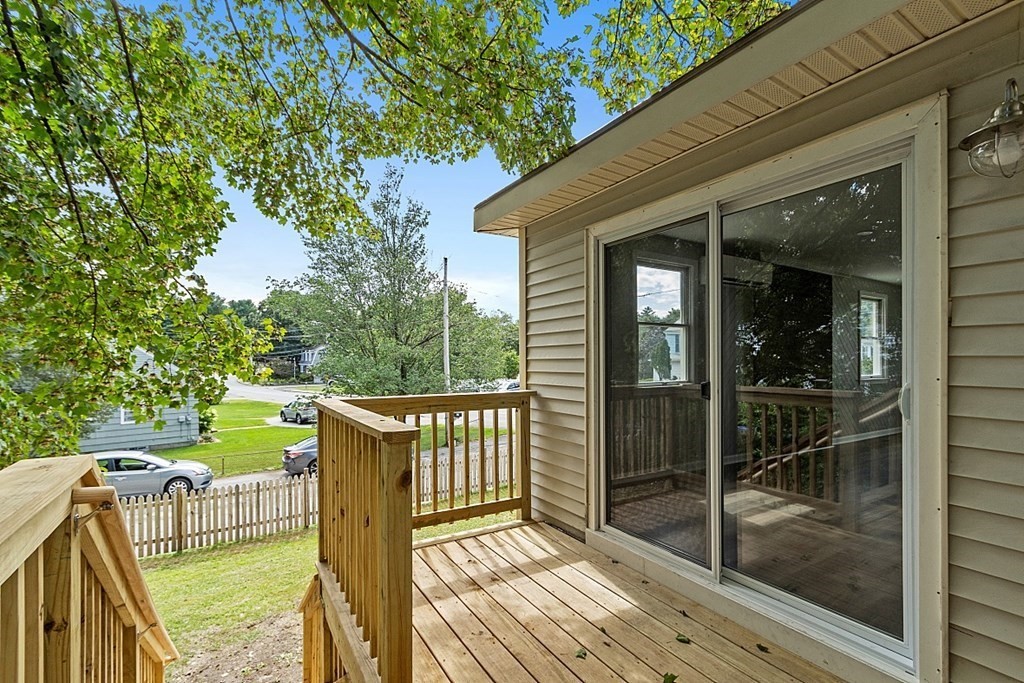 46 West Meadow Road Lowell, MA 01854 - Photo 6 of 42 a view of a deck with a floor to ceiling window and wooden fence