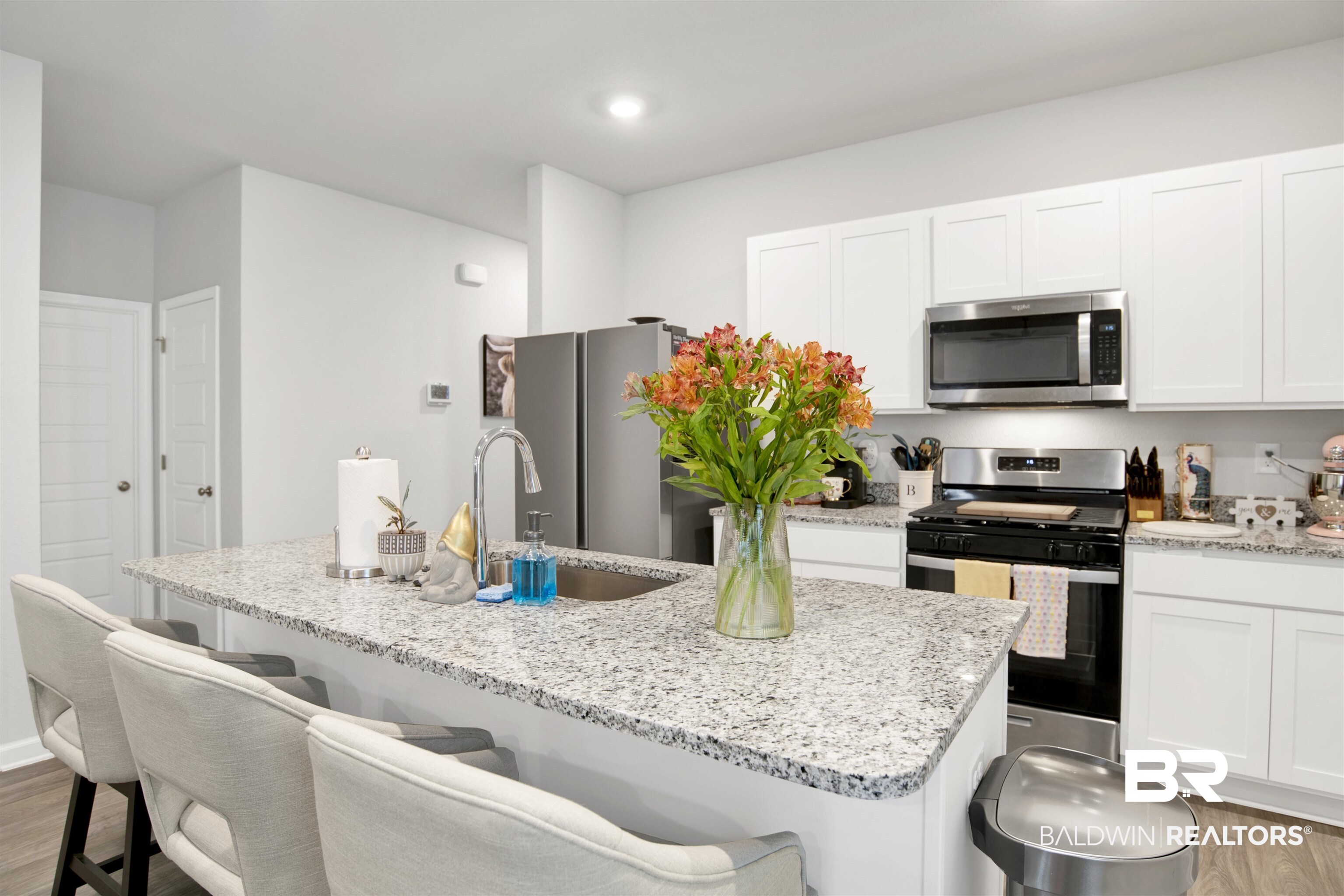 12813 Patriot Way Daphne, AL 36527 - Photo 3 of 23 Kitchen featuring white shaker cabinetry, stainless steel appliances, a center island with bar seating, and a dual-basin sink with a gooseneck faucet