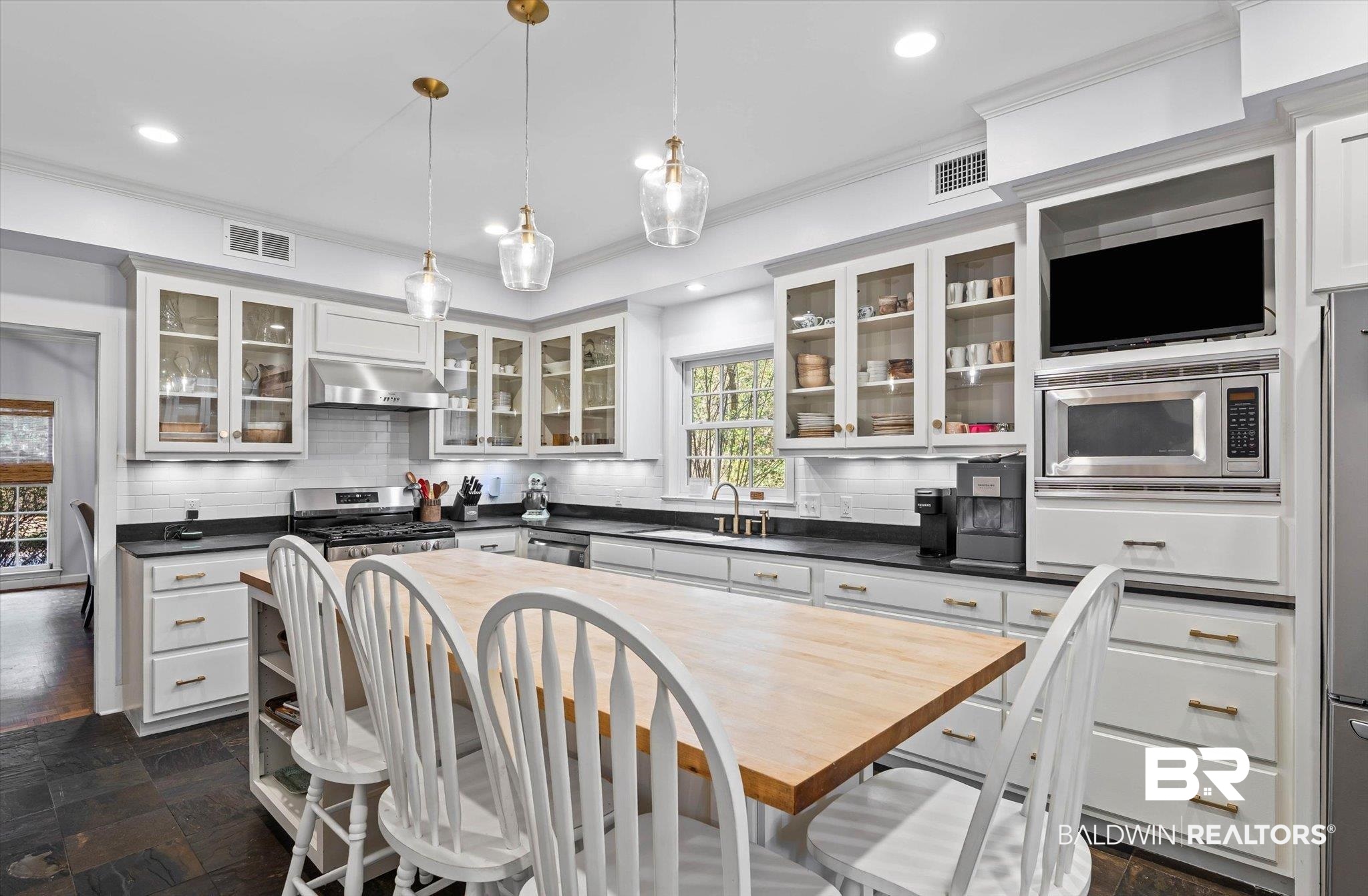 4776 Falls Church Road Mobile, AL 36608 - Photo 8 of 45 Kitchen featuring a substantial wood-finish island, white cabinetry with glass-front uppers, and stainless steel appliances