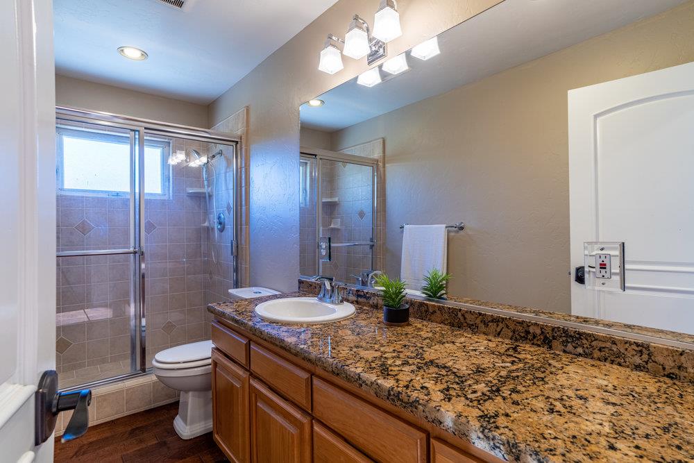 2985 Day Road Gilroy, CA 95020 - Photo 39 of 72 a bathroom with a granite countertop sink toilet a large mirror and shower