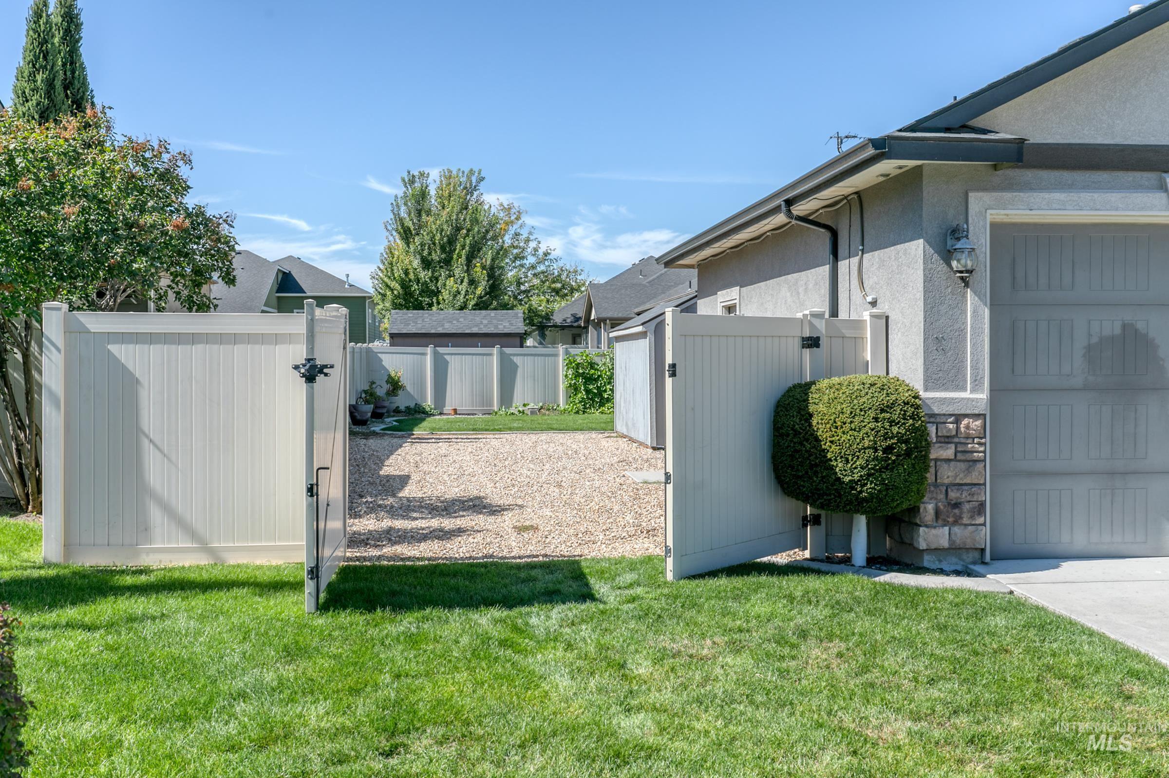 4316 Middlesboro Way Caldwell, ID 83607 - Photo 6 of 33 Gravel side yard featuring a privacy fence, stucco exterior, and an exterior access door