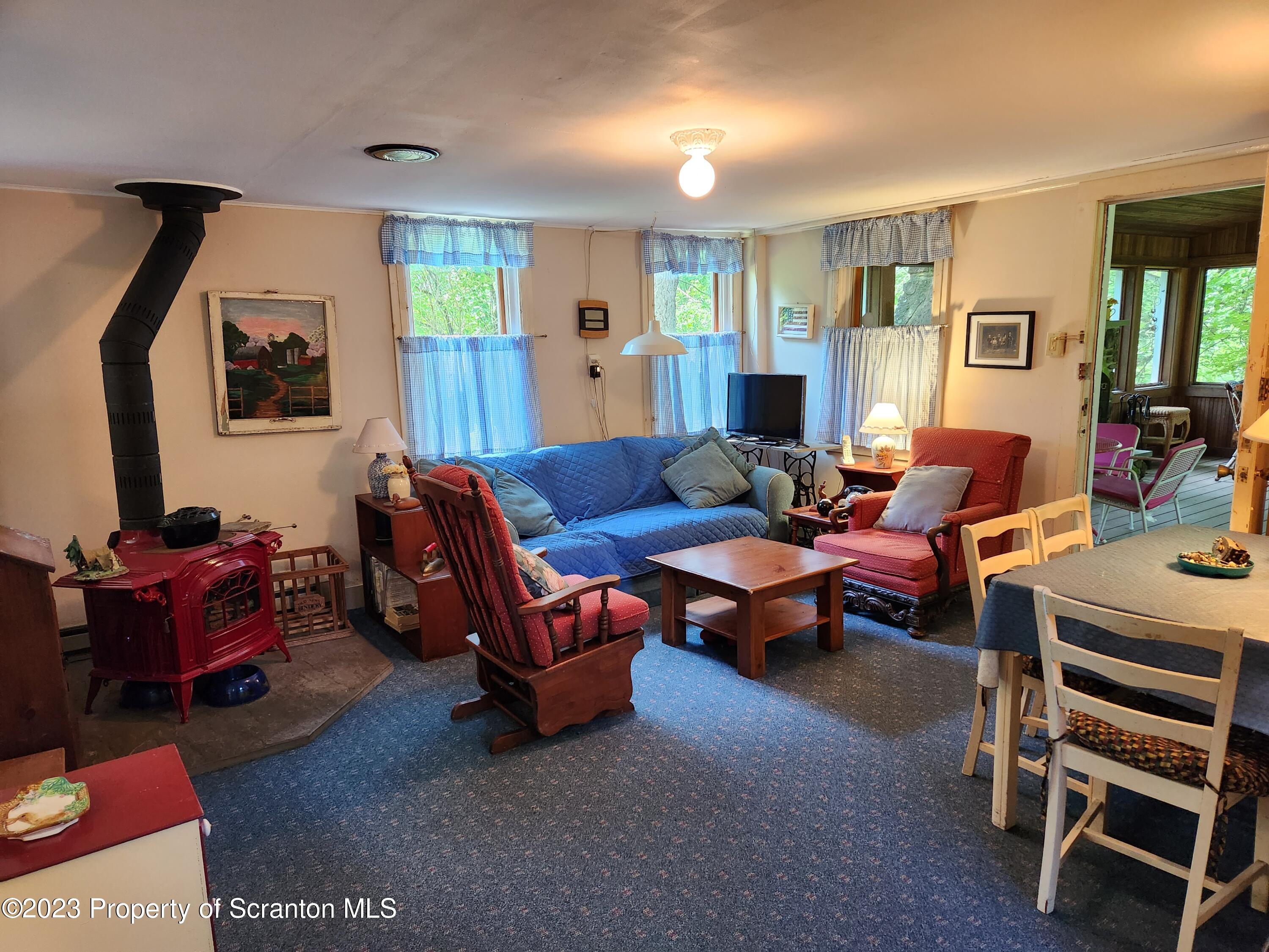 577 Farley Road Meshoppen, PA 18630 - Photo 6 of 35 a living room with furniture a flat screen tv and paintings on the wall