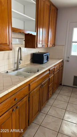 a kitchen with granite countertop a stove top oven and cabinets