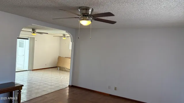 an empty room with windows and fan