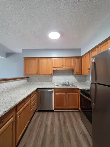 a kitchen with granite countertop stainless steel appliances and wooden cabinets