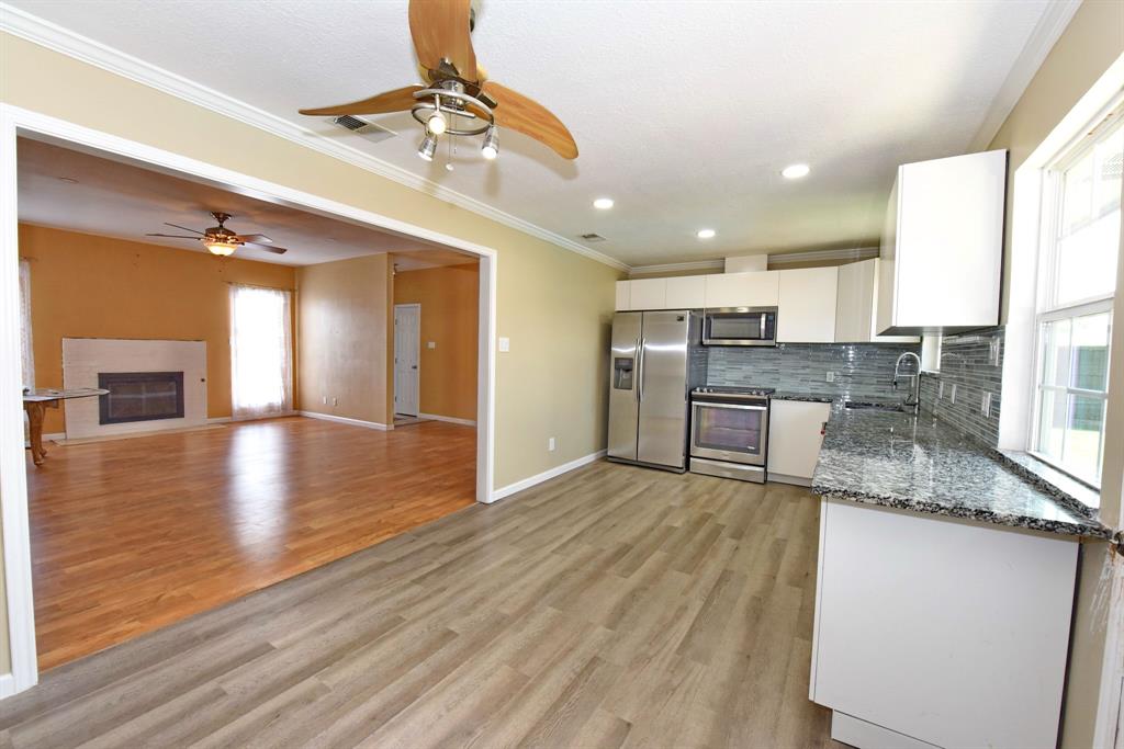 a large kitchen with granite countertop a large counter top and stainless steel appliances
