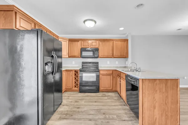 a kitchen with stainless steel appliances granite countertop a refrigerator a sink a stove and island
