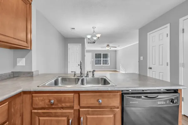 a kitchen with granite countertop a sink stainless steel appliances and cabinets