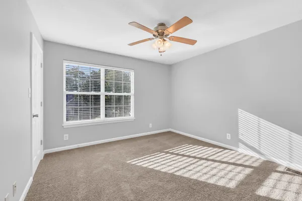 an empty room with cabinet and windows