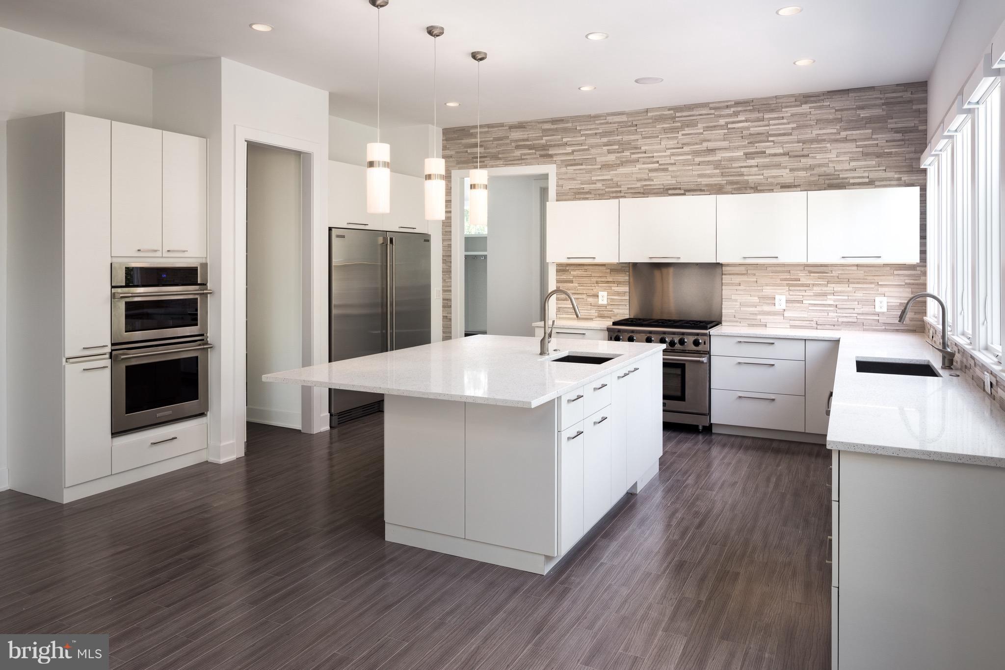 1217 Crest Lane McLean, VA 22101 - Photo 13 of 28 a kitchen with a center island wooden floor and stainless steel appliances