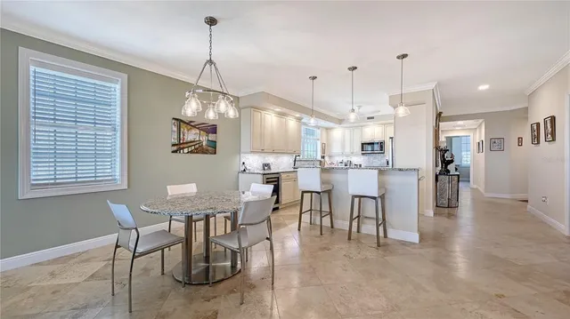 a dining room with stainless steel appliances kitchen island granite countertop a table and chairs