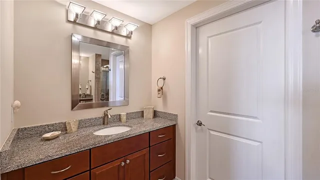 a bathroom with a granite countertop sink and a mirror